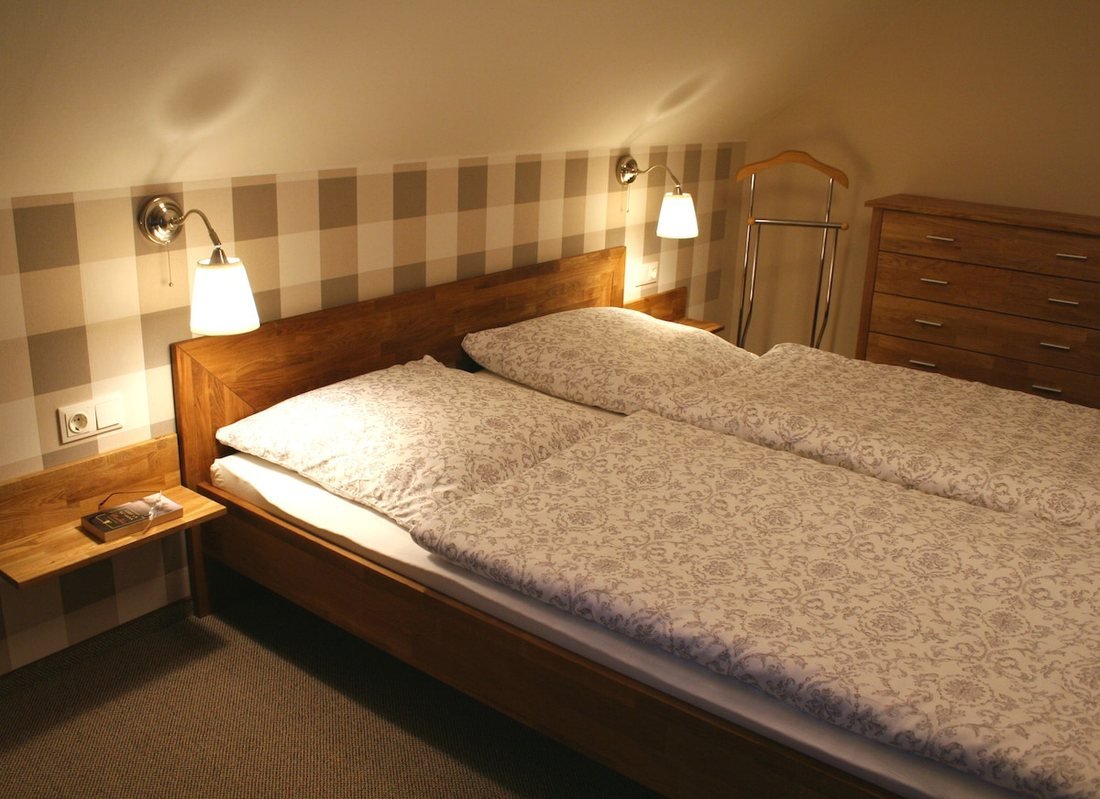 Schlafzimmer mit Doppelbett, Leselampen und Holzkopfteil