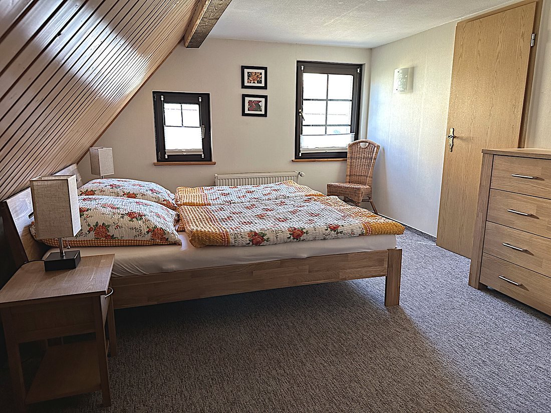 Schlafzimmer mit Doppelbett unter der Dachschräge
