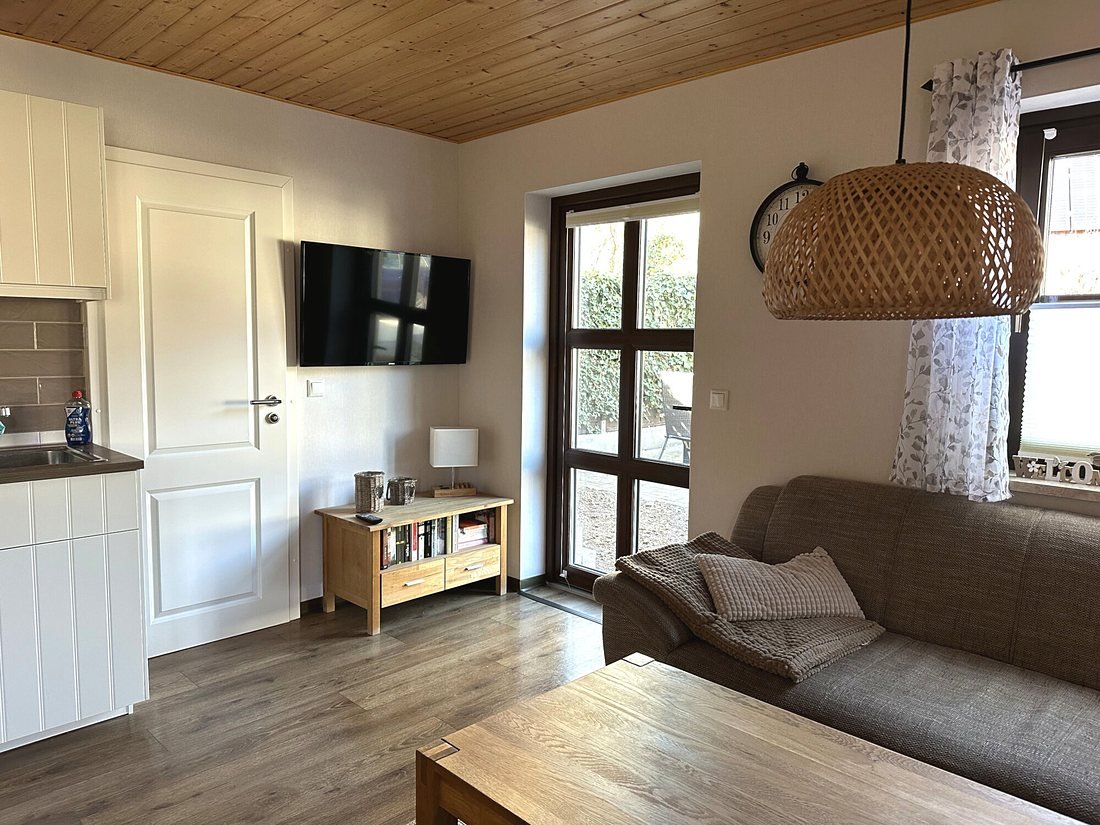 Wohnraum mit Fernseher und Tür zur Terrasse